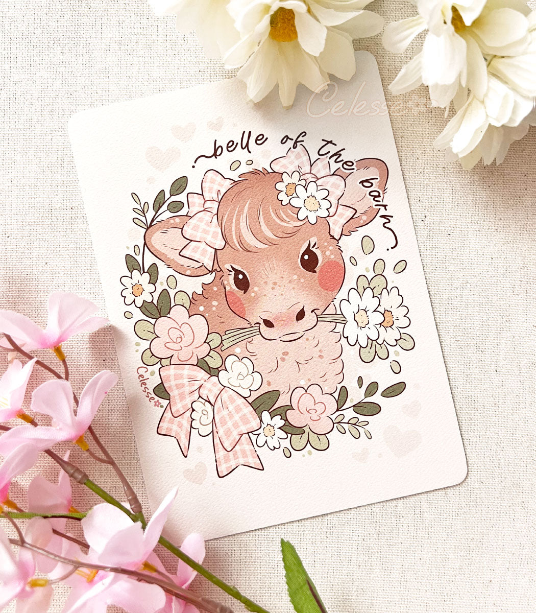 A photo of a textured print with a vintage style drawing of a portrait of a brown cow. She has pink gingham bows on her ears and is holding daises in her mouth. A floral wreath with a matching bow rings around her neck.