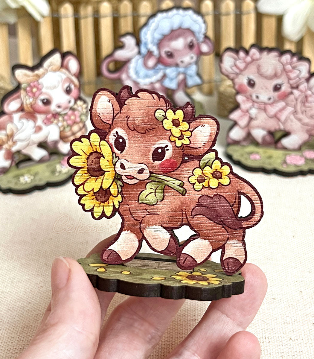 A photo of a wood standee featuring a baby brown cow holding sunflowers in their mouth and trotting on a patch of grass.