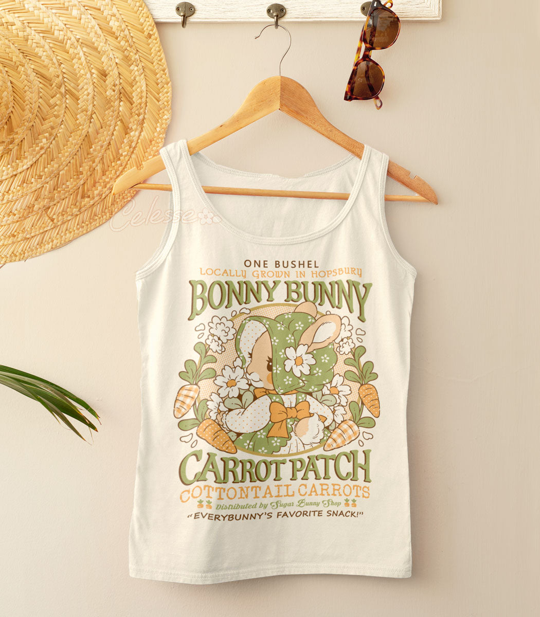 A natural-colored shirt on a wooden hanger with a straw hat and sunglasses. The print features a faux logo for Bonny Bunny Carrot Patch with a rabbit in an old-fashioned bonnet and dress holding flowers.