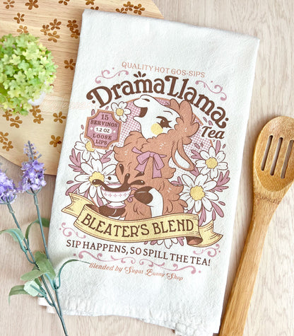 A white kitchen tea towel with a vintage-style logo for Drama Llama Bleater&