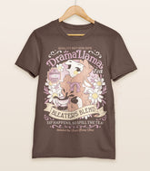 A brown shirt on a wood hanger with a print for a faux vintage-style logo for Drama Llama Tea, the art featuring a gossipy llama spilling the tea.