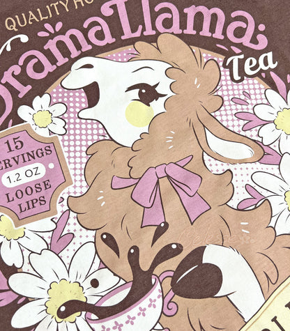 A close up of a brown shirt with a print for a faux vintage-style logo for Drama Llama Tea, the art featuring a gossipy llama spilling the tea.