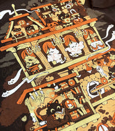 A close-up photo of a dark brown shirt, the print featuring a whimsical Halloween-themed haunted home full of witch cats and ghosts.