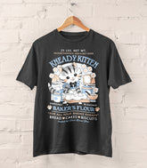 A photo of a dark gray shirt on a wood hanger, the print featuring a faux logo for Kneady Kitten Baker&