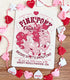 An art print on a table decorated with a string of hearts with a logo for Pink Pony Club, the art featuring a prancing pink pony in frilly décor. The flavor text reads "Bridle up, it&
