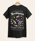 A black shirt on a wood hanger with a print of a retro faux candy logo for Sparklepaws Popping Candy, the art featuring a black cat with star paw pads leaping among bursting sparkles. The flavor text reads, "Dazzlingly delicious!" and "Frolic among the stardust!"