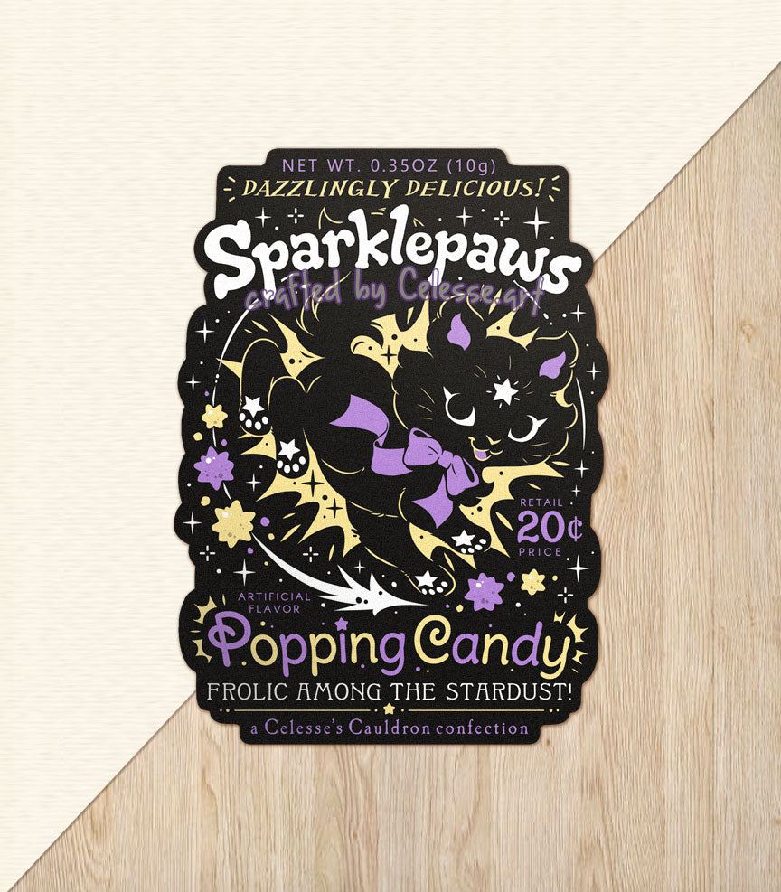 A vinyl sticker with a print of a retro faux candy logo for Sparklepaws Popping Candy, the art featuring a black cat with star paw pads leaping among bursting sparkles. The flavor text reads, "Dazzlingly delicious!" and "Frolic among the stardust!"